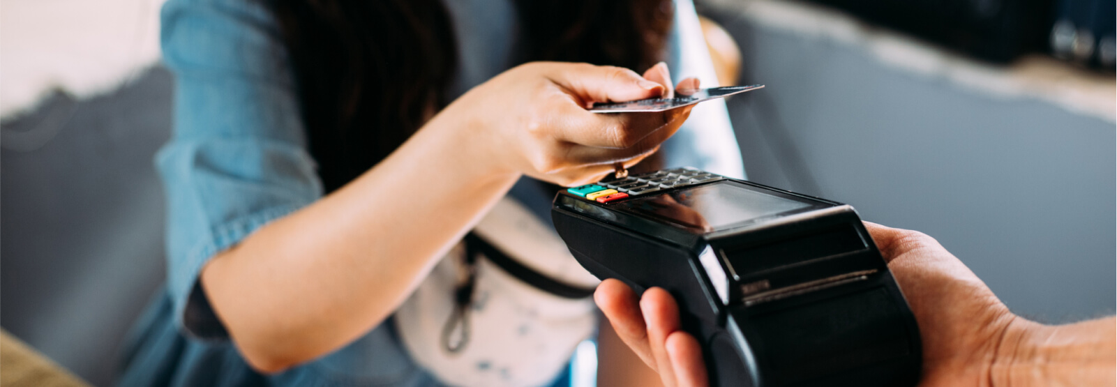 Close up of people's hands using a card reader for payment