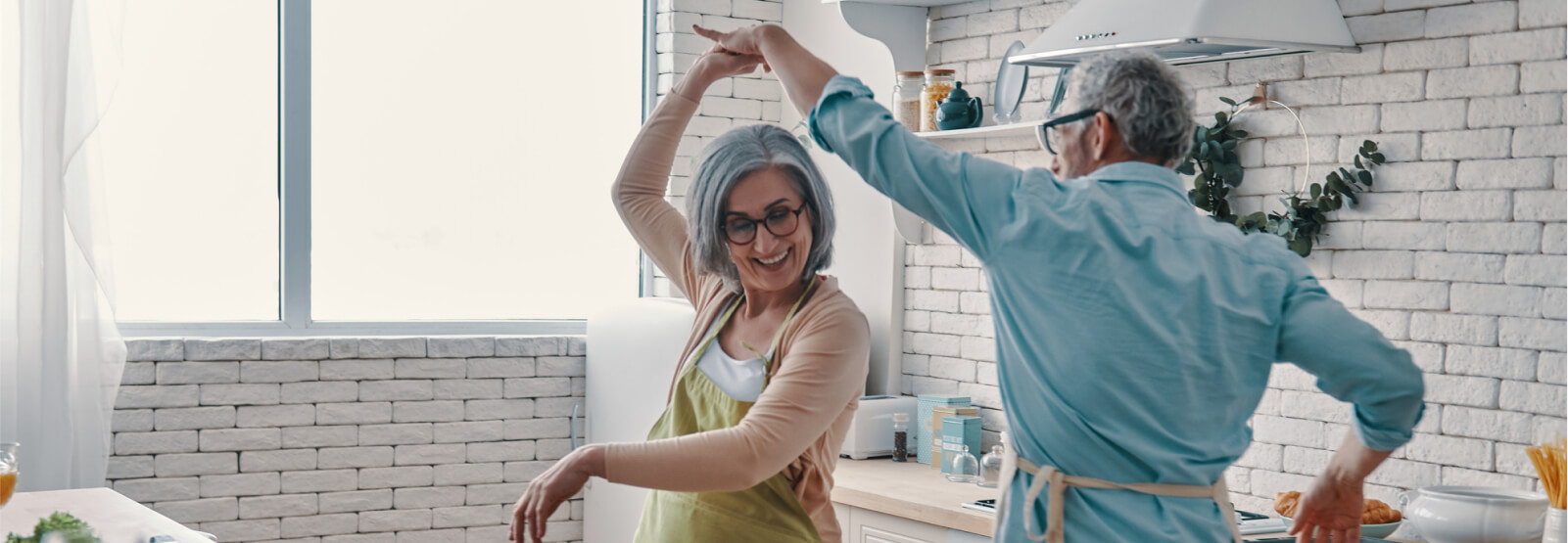 An older couple dancing in a modern kitchen